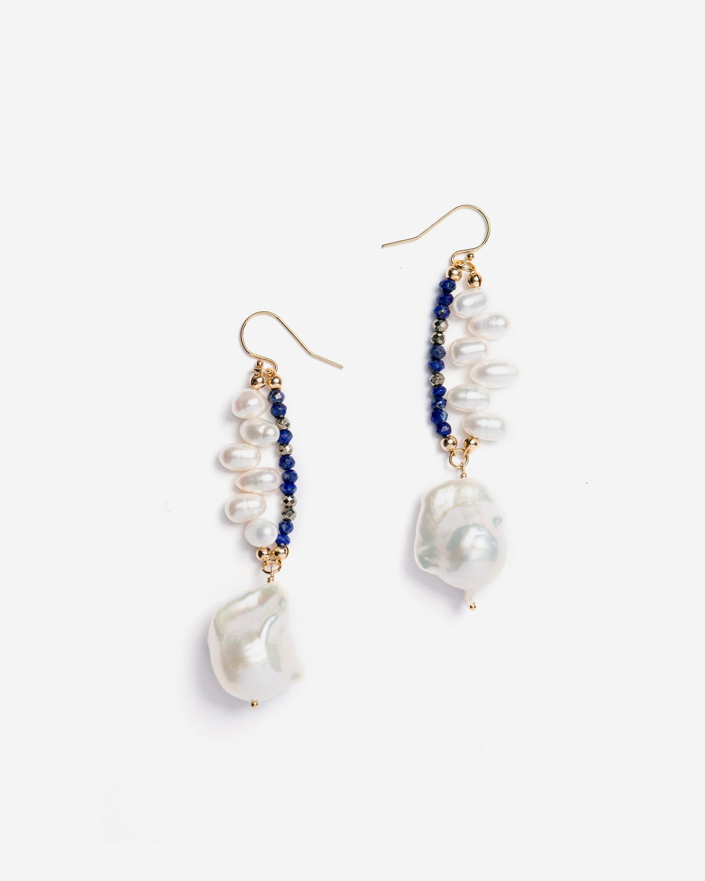 monái baroque pearl lapis lazuli earrings laid flat – handcrafted design featuring luminous baroque pearls, deep blue lapis lazuli, golden pyrite, and 14K gold-filled hardware