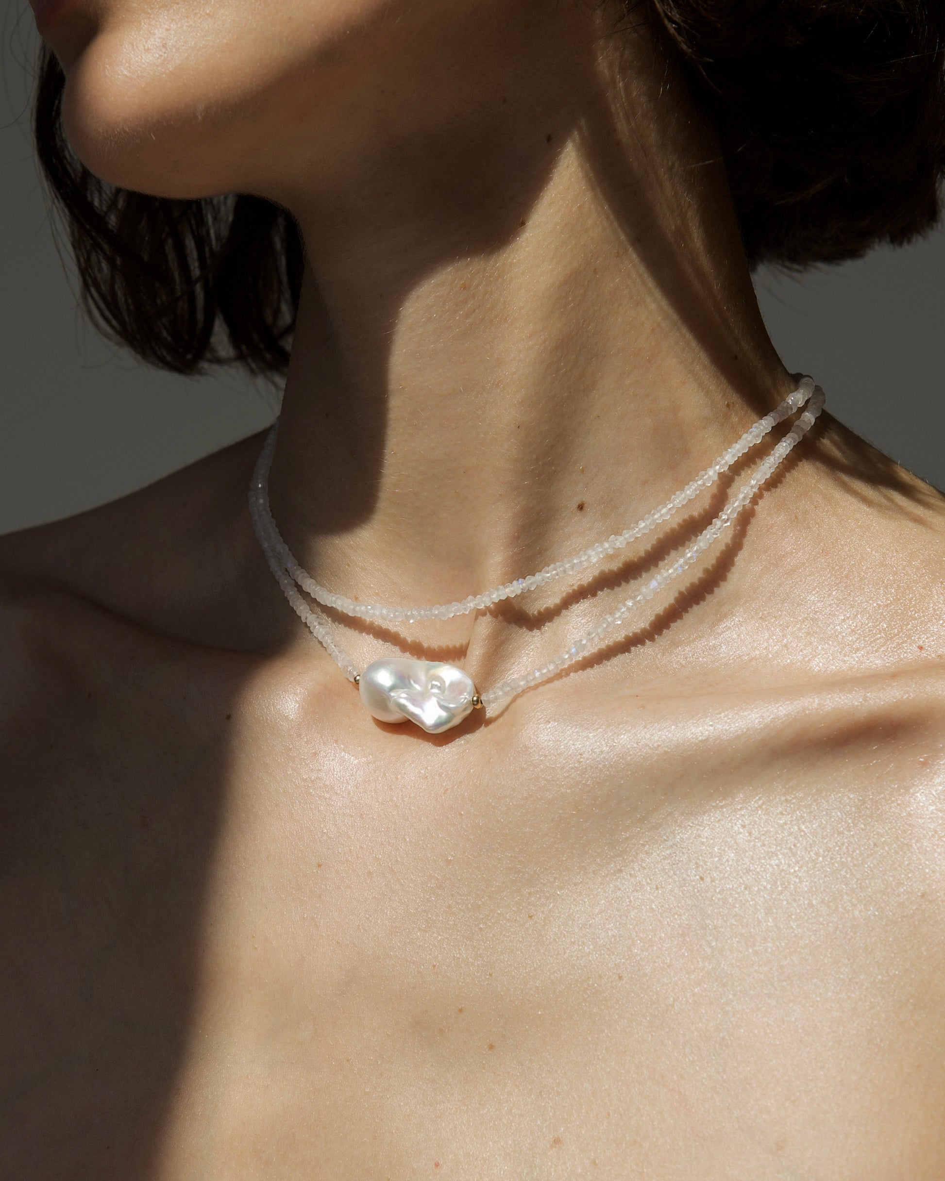 monái baroque pearl rainbow moonstone necklace styled on model – elegant, close-fitting necklace that enhances the neckline with iridescent stones and natural pearl detail
