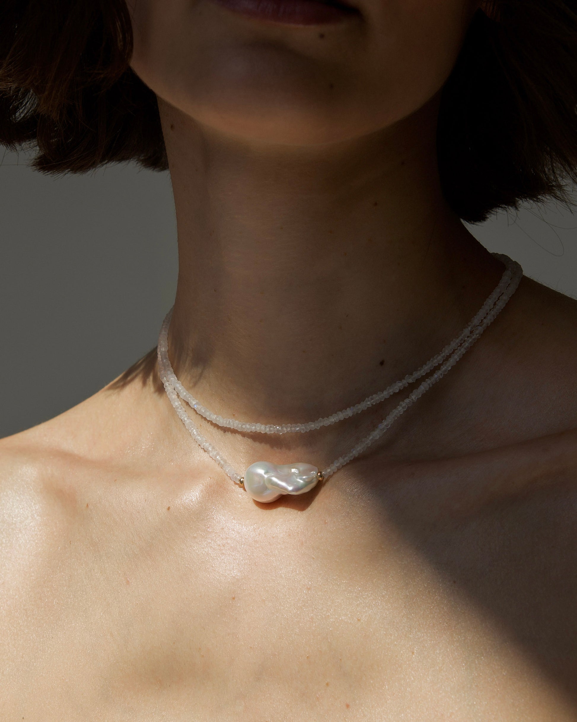 monái baroque pearl rainbow moonstone necklace styled on model – elegant, close-fitting necklace that enhances the neckline with iridescent stones and natural pearl detail