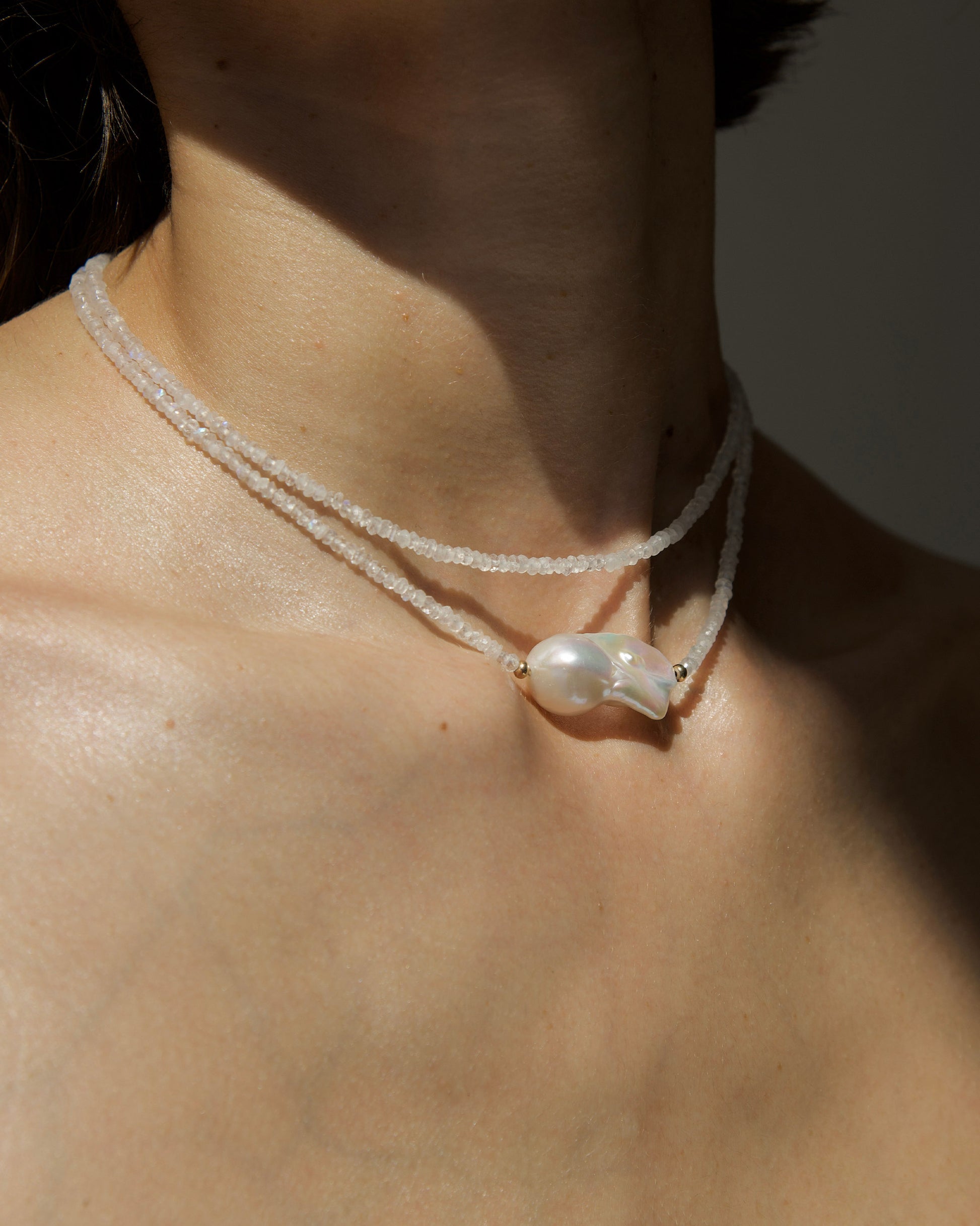 monái baroque pearl rainbow moonstone necklace styled on model – elegant, close-fitting necklace that enhances the neckline with iridescent stones and natural pearl detail