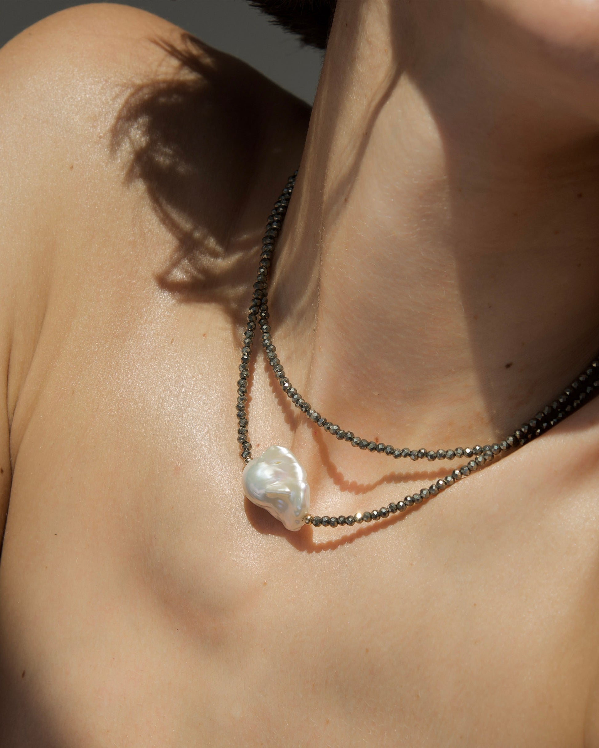 monái baroque pearl pyrite necklace laid flat – handcrafted design featuring luminous baroque pearls, faceted pyrite gemstones, and 14K gold-filled hardware