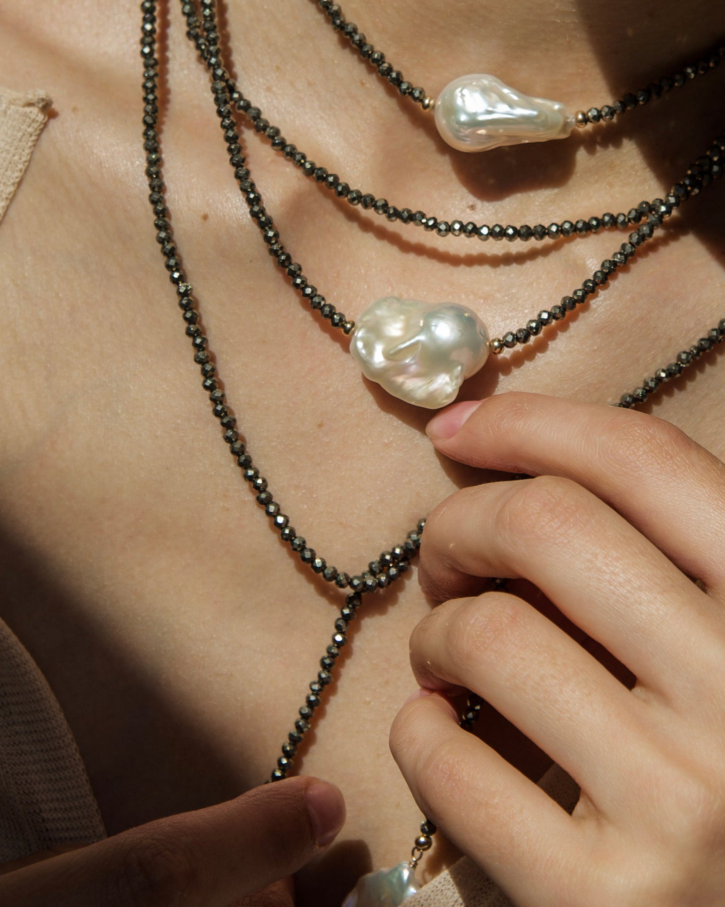 monái long baroque pearl pyrite necklace styled in a knot on model – showcasing the piece's adaptability and bold design
