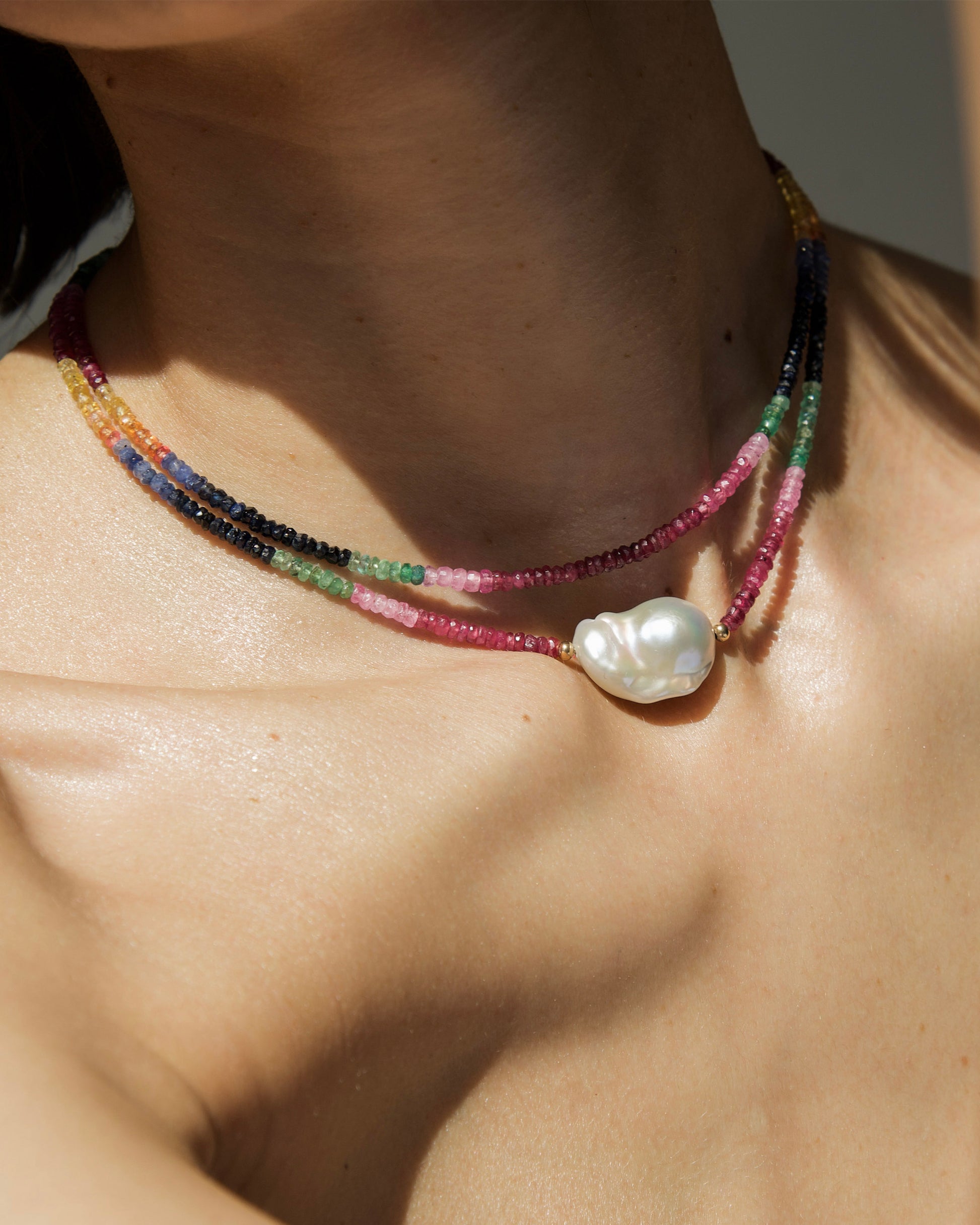 close-up of monái baroque pearl rainbow necklace showcasing AAA+ quality baroque pearls paired with hand-cut ruby, emerald, blue and yellow sapphire gemstones – a harmonious blend of organic form and vibrant color