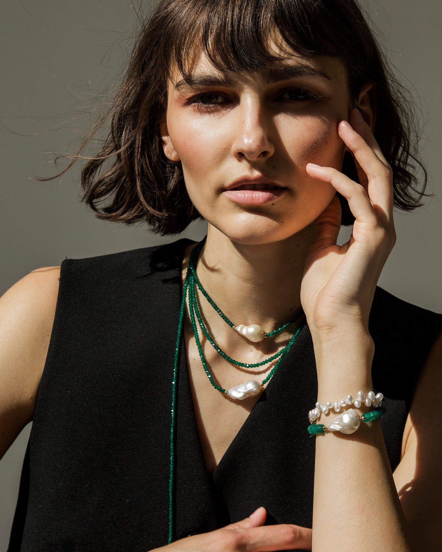 model wearing monái’s green onyx accent pearl bracelet with long baroque pearl and green onyx necklace – layered handcrafted jewelry celebrating bold contrast and organic elegance