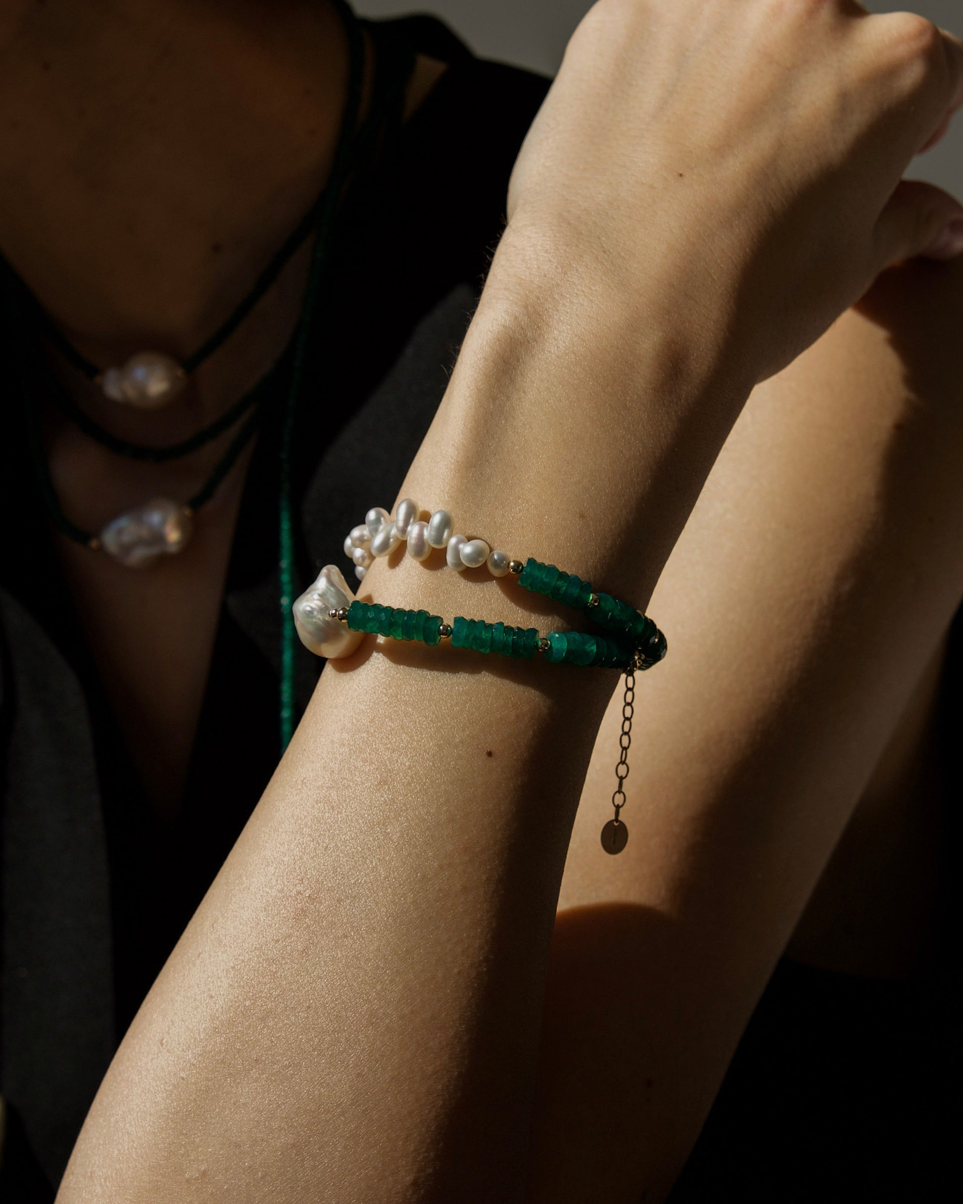 monái green onyx accent pearl bracelet styled on wrist with green onyx asymmetric bracelet – bold yet minimalist piece for everyday creative expression