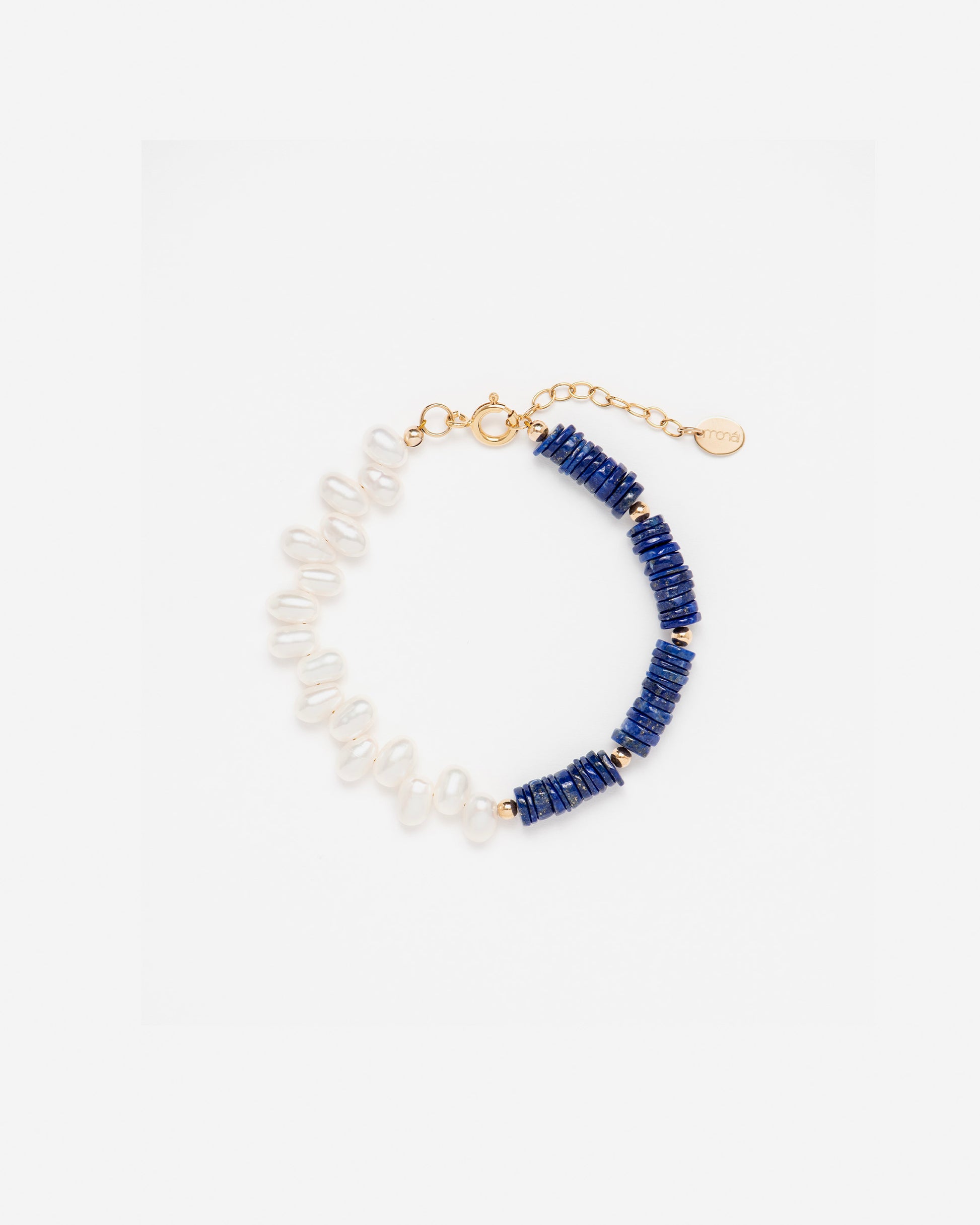 monái lapis lazuli asymmetric bracelet laid flat – handcrafted design featuring deep blue lapis lazuli, luminous baroque pearl, and 14K gold-filled hardware