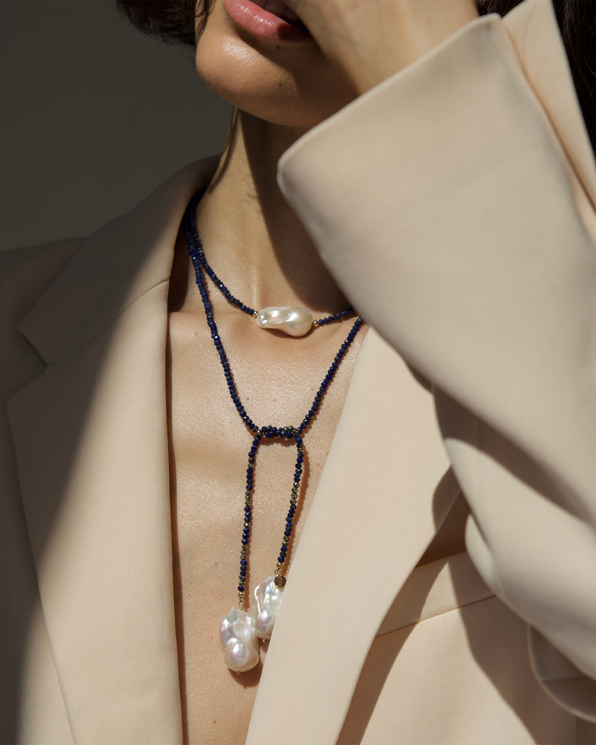 monái long baroque pearl lapis lazuli necklace knotted at the front – showcasing the piece's adaptability and bold design