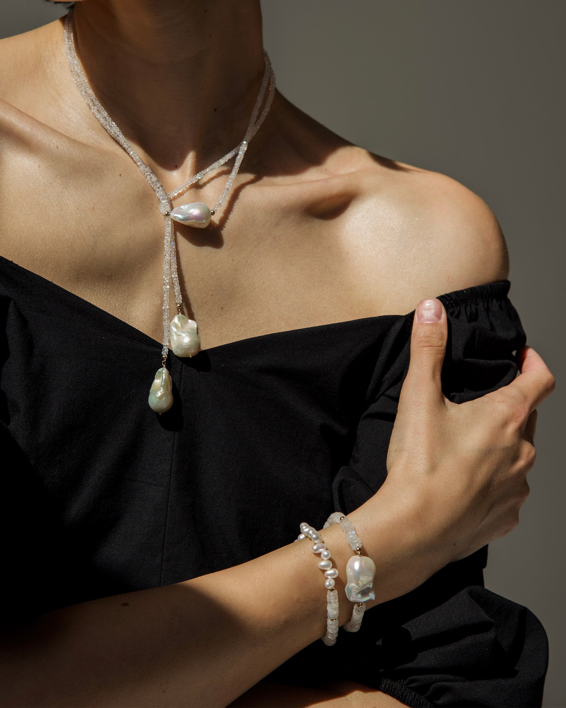 monái long baroque pearl rainbow moonstone necklace styled in a knot on model – showcasing the piece's adaptability and bold design