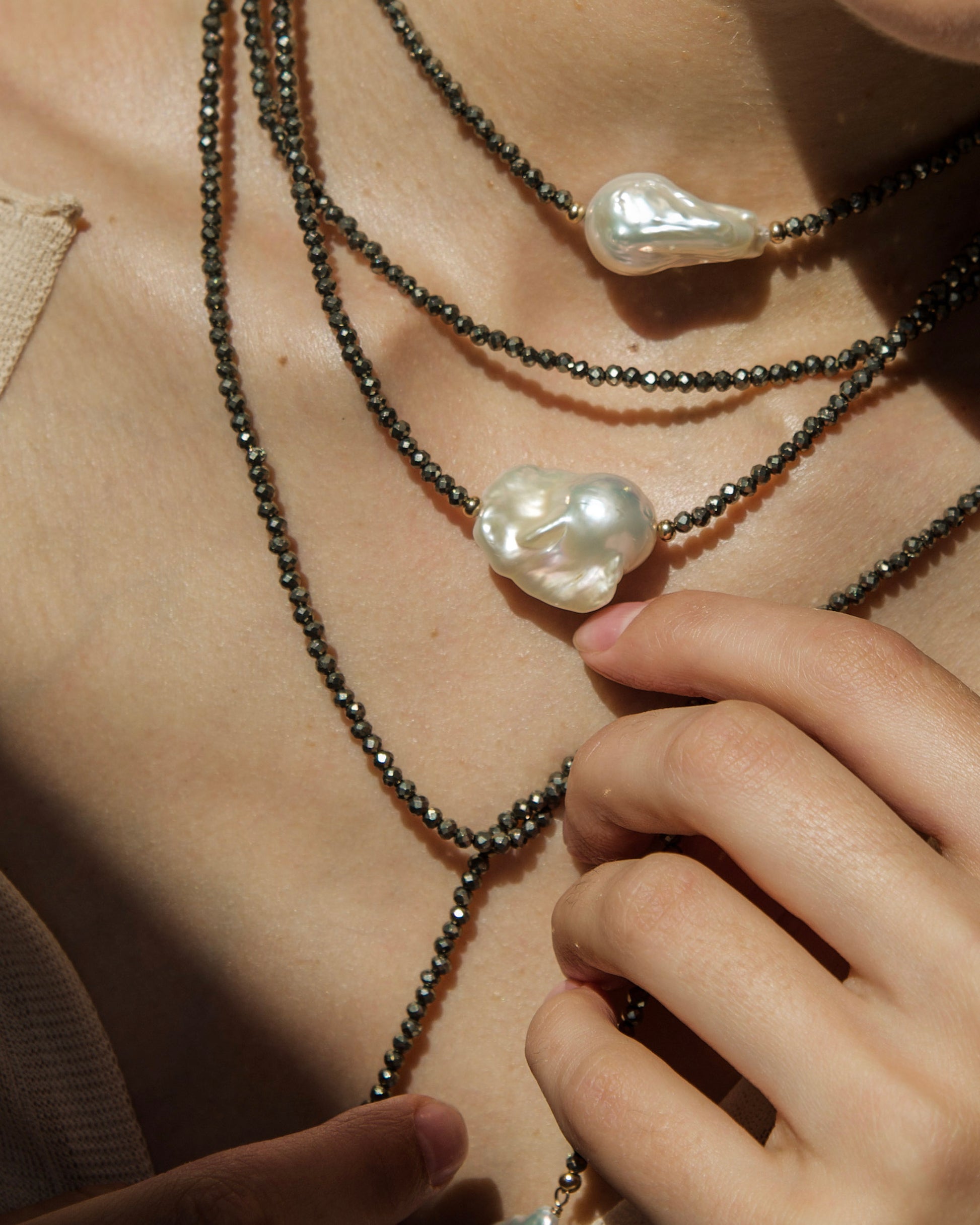 close-up of monái long baroque pearl pyrite necklace showcasing AAA+ quality baroque pearls paired with hand-cut pyrite gemstones – a harmonious blend of organic form and metallic shimmer