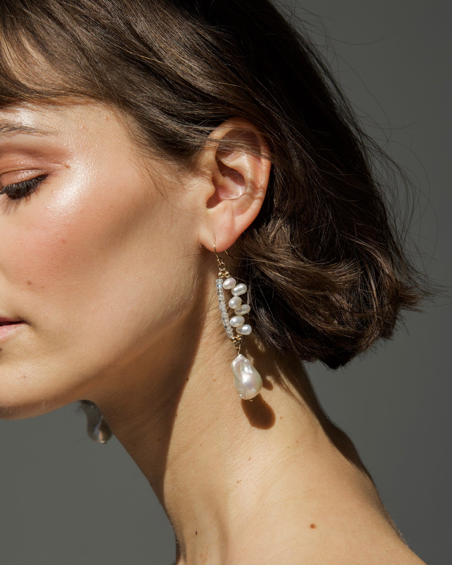 close-up of monái earrings showcasing AAA+ quality baroque pearls paired with hand-cut rainbow moonstone gemstones – a harmonious blend of organic form and ethereal shimmer